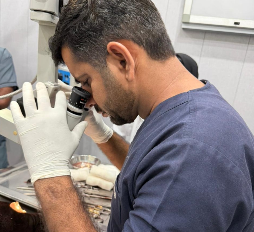 Dr. Abid Hussain examining pet eye through surgical microscope for glaucoma diagnosis at Abid Pets Hospital